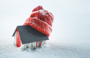 model-of-a-house-in-the-snow-wearing-a-red-winter-hat